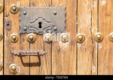 Serrure dans une vieille porte en bois orné de meubles anciens ; poignée de porte et patiné rouillé Banque D'Images