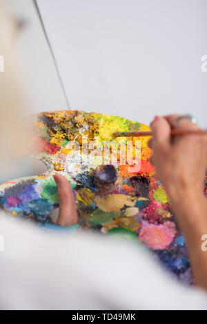 Gouache et peinture. Vue de dessus le mélange gouache peinture femme avec pinceau avant peinture Banque D'Images