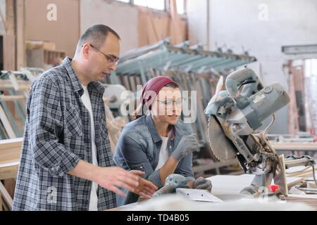Industriel Portrait des travailleurs, hommes et femmes, des gens parler au travail, les meubles menuiserie production. Banque D'Images
