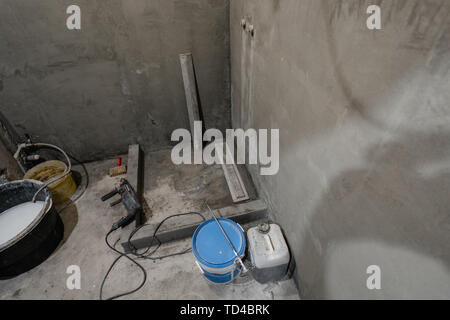 La base d'une cabine de douche. Salle de bains au cours de travaux de finition. Pose des tuiles sur le mur et le plancher. Accueil rénovation, démolition dans la salle de bains. Banque D'Images