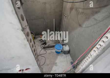 La base d'une cabine de douche. Salle de bains au cours de travaux de finition. Pose des tuiles sur le mur et le plancher. Accueil rénovation, démolition dans la salle de bains. Banque D'Images