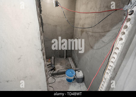 La base d'une cabine de douche. Salle de bains au cours de travaux de finition. Pose des tuiles sur le mur et le plancher. Accueil rénovation, démolition dans la salle de bains. Banque D'Images