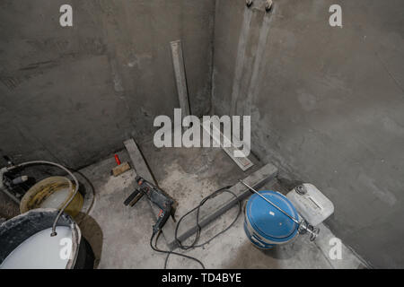 La base d'une cabine de douche. Salle de bains au cours de travaux de finition. Pose des tuiles sur le mur et le plancher. Accueil rénovation, démolition dans la salle de bains. Banque D'Images