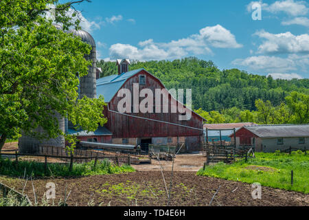 Vieux rustique grange rouge qui est une ferme assis le long d'une colline dans le Wisconsin rural, sur un après-midi ensoleillé Banque D'Images