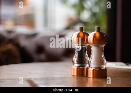 Un bronze Sel et poivre shaker et grinder s'asseoir sur une table à l'intérieur d'un restaurant irlandais Banque D'Images