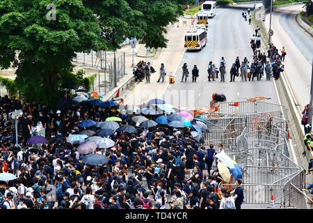 Hong Kong. 12 Juin, 2019. Hong Kong - le 12 juin 2019. Des milliers de manifestants ont entouré des bâtiments gouvernementaux à Hong Kong pour protester contre un projet de loi sur l'extradition controversée. Les agents de police anti-émeute sont confrontés à des manifestants. Gonzales : Crédit Photo/Alamy Live News Banque D'Images