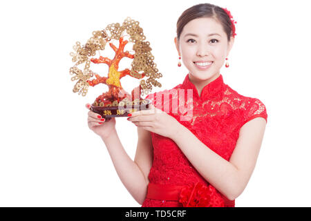 Young Asian Woman in cheongsam rouge détient la chance arbre dans le nouvel an chinois Banque D'Images