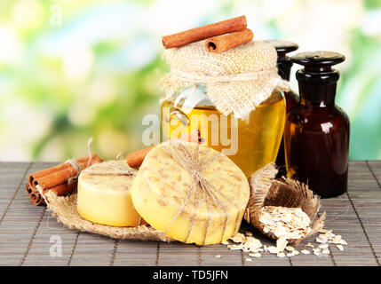 Savon fait main et ingrédients pour la fabrication du savon sur le tapis de bambou, sur fond vert Banque D'Images