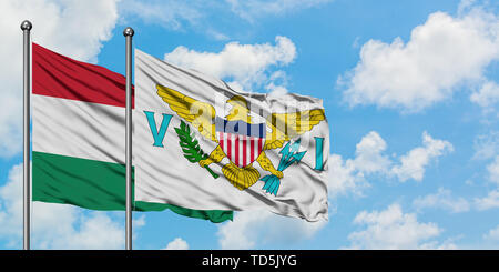 La Hongrie et les Îles Vierges Américaines drapeaux dans le vent contre ciel bleu nuageux blanc ensemble. Concept de diplomatie, de relations internationales. Banque D'Images
