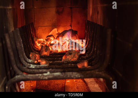 La combustion des charbons ardents et lumineux en bois barbecue fosse. Flaming éclatante et d'un charbon, barbecue, feu rouge et des cendres. Week-end d'arrière-plan des loisirs. Close-up Banque D'Images