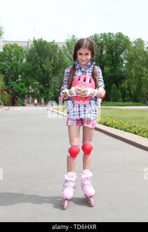 Petite fille en patins à roulettes à park Banque D'Images