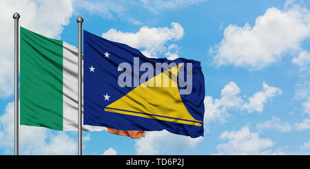 L'Irlande et les Tokélaou drapeaux dans le vent contre ciel bleu nuageux blanc ensemble. Concept de diplomatie, de relations internationales. Banque D'Images