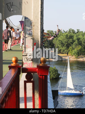 Kiev, Ukraine. 12 Juin, 2019. Une femme saut saute d'une passerelle au-dessus de la rivière Dnipro chaude journée d'été à Kiev, Ukraine, le 12 juin 2019. La chaleur d'été est tombée à Kiev. La température a dépassé la marque de 31 degrés Celsius : Crédit Sergii Kharchenko/ZUMA/Alamy Fil Live News Banque D'Images