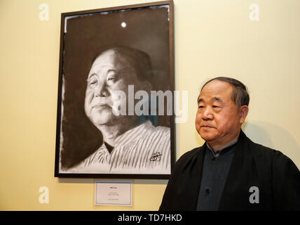 Oxford, UK. 12 Juin, 2019. L'écrivain chinois Mo Yan, Prix Nobel et pose avec un portrait de lui-même après la cérémonie de remise de bourses d'honneur à l'Université d'Oxford, Grande-Bretagne, le 12 juin 2019. Mo Yan a reçu mercredi la bourse honorifique par Regent's Park College, Université d'Oxford, en reconnaissance de sa contribution à la littérature mondiale et chinois. Le principal du collège Robert Ellis a présenté la robe et a volé à lu à la cérémonie. Ils ont dévoilé un nouveau centre international de l'écriture du nom de crédit ve : Xinhua/Alamy Live News Banque D'Images