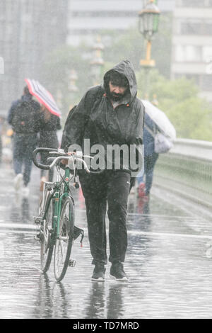 Londres, Royaume-Uni. 13 juin 2019. Les piétons sont frappés par des pluies torrentielles et de fortes pluies traversant le pont de Westminster de Londres. Credit : amer ghazzal/Alamy Live News Banque D'Images