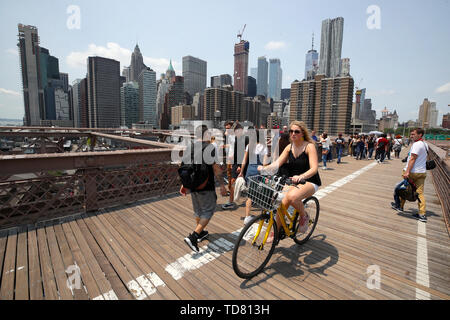 Les cyclistes sur le pont de Brooklyn à la passerelle à Lower Manhattan et Wall Street Banque D'Images