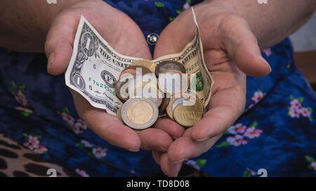 Vieille Femme implore pour l'aumône. Libre d'argent et pièces de monnaie dans la main de femme pauvre. Les problèmes sociaux de la société Banque D'Images