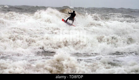 Un kite surfer prend avantage des forts vents à Tynemouth Beach au nord-est. Banque D'Images