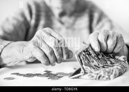Photo gros plan détaillé de womans mains âgées méconnaissable restants de comptage de pièces dans son portefeuille de retraite après le paiement des factures. Banque D'Images