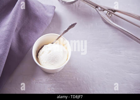 Crème glacée à la vanille sur un bol en papier blanc, gris serviette sur une table gris avec crème glacée. Oriental. Le minimalisme. Banque D'Images