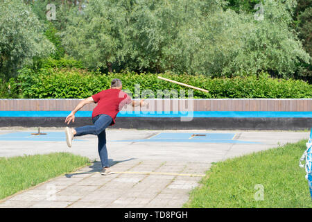 Homme jouant de gorodki, populaire et folklorique russe ancien scandinave sport Banque D'Images