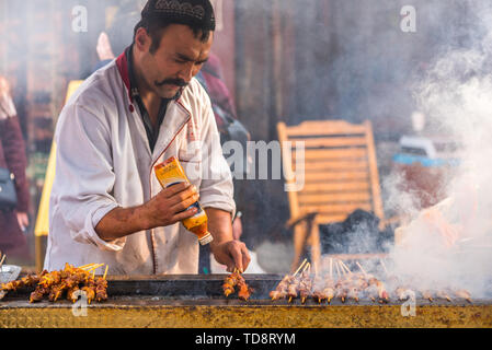 Chengdu, Sichuan Province, China - Dec 16,2015 : Un homme les brochettes d'agneau barbecue près de monastère de Wenshu Banque D'Images