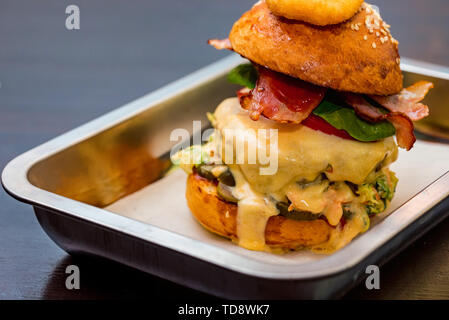 Close up tall tasty burger avec fromage servi sur le bac Banque D'Images