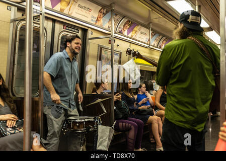 La ville de New York, USA - 31 juillet 2018 : le batteur et le guitariste jouant à l'intérieur d'un wagon de métro avec des personnes dans la région de New York City, USA Banque D'Images