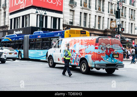 La ville de New York, USA - 31 juillet 2018 : femme musulmane policier diriger la circulation lever la main pour que les gens passent devant Macys departme Banque D'Images