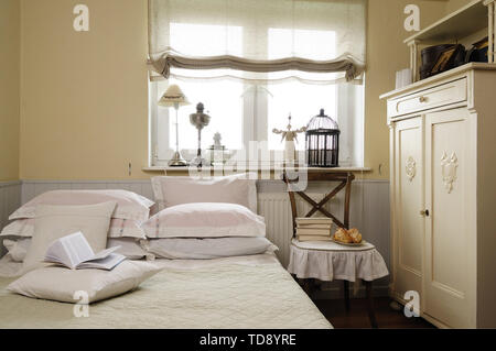 Pile de livres sur la chaise à côté de vintage armoire dans la chambre UK & IRISH UTILISEZ UNIQUEMENT Banque D'Images