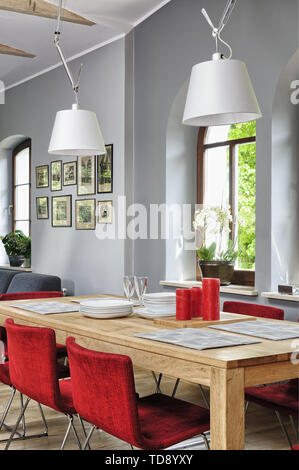 Chaises rouges à table dans la salle à manger avec des poutres au plafond et plancher en bois de l'homme britannique et irlandais seulement Banque D'Images