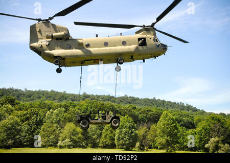 Des soldats américains avec la Compagnie Alpha, 628e Bataillon de soutien à l'Aviation, 28e Brigade d'aviation de combat expéditionnaire charge sous élingue une Humvee à un hélicoptère CH-47 Chinook exploités par des soldats de la Compagnie Bravo, 2-104ème bataillon de l'aviation d'appui général, 28e à l'ECAB Fort Indiantown Gap, le 12 juin 2019. Des Humvees ont été transportés à Schuylkill Comté Joe Zerbey Airport. Banque D'Images