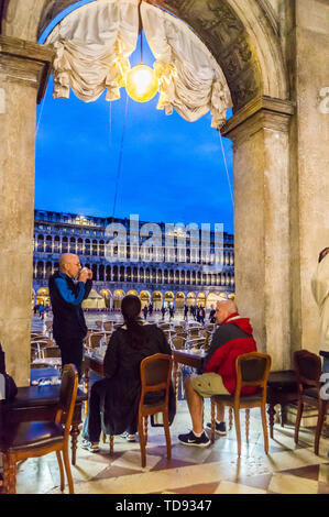 Un groupe d'alcool au Café Florian, la Place Saint-Marc, San Marco, au crépuscule, Venise, Vénétie, Italie Banque D'Images