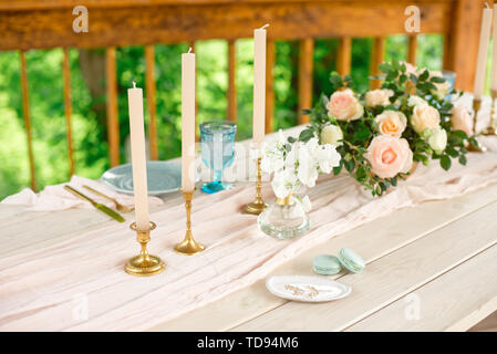 Table décoration de mariage dans le jardin, arrangement de fleurs,des bougies dans le style vintage sur l'extérieur. Gâteau de mariage avec des fleurs. Table décorée avec fl Banque D'Images