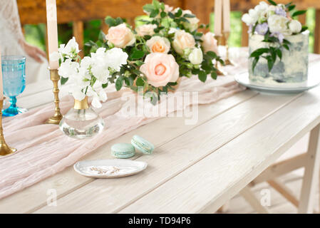 Table décoration de mariage dans le jardin, arrangement de fleurs, dans le style vintage sur l'extérieur. Gâteau de mariage avec des fleurs. Table décorée avec des fleurs, Banque D'Images