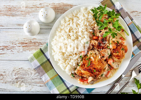 Fricassée de poulet chaud sur une plaque avec de la viande de poulet - riz doré et mijotée dans du vin blanc, sauce crème aux champignons et légumes, classique français r Banque D'Images