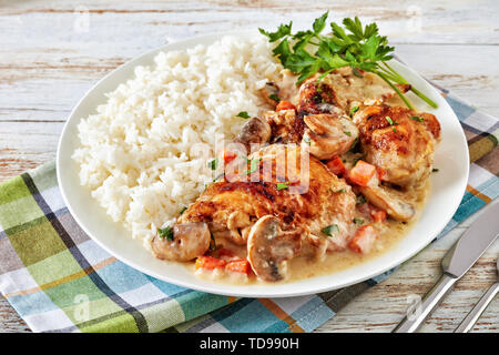 Fricassée de poulet sur une plaque avec de la viande de poulet - riz doré et mijotée dans du vin blanc, sauce crème aux champignons et légumes, recip française classique Banque D'Images