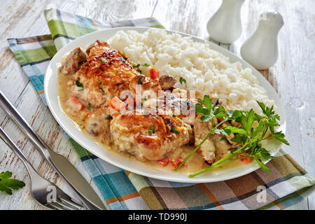 Compotée de poulet à la crème et sauce au vin blanc, champignons et légumes et servi avec du riz dans une assiette avec du riz - Fricassée de poulet, fre classique Banque D'Images