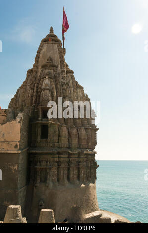 Temple Hindou avec murs sculptés un spire et drapeau sur la côte de la mer bleue Banque D'Images