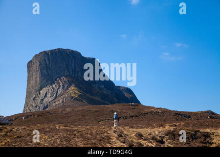 Une personne qui marche vers l'impressionnante colline de Ann Sgurr sur l'île de Eigg en Écosse. Banque D'Images