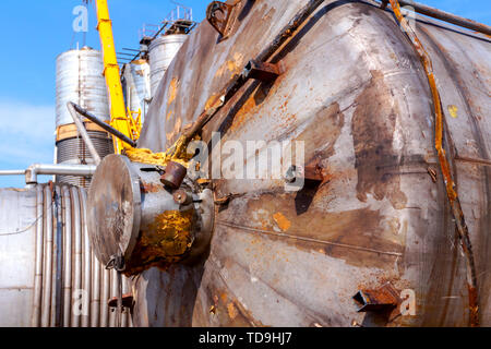 Vieux massif obsolètes silos métalliques, les réservoirs sont couchés sur le sol, attendant cassation pour le recyclage du métal. Banque D'Images