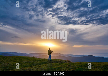 Homme jouant locales (traditionnel turc - Karadeniz - Laz) instrument de musique cornemuse Tulum au coucher du soleil, au Plateau Pokut, Rize, Turquie Banque D'Images