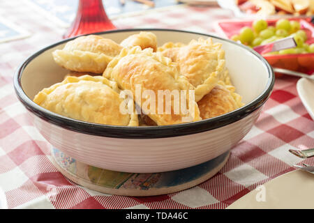 Bol de boulangerie juste des empanadas argentines sur une table avec d'autres aliments pour une célébration Banque D'Images