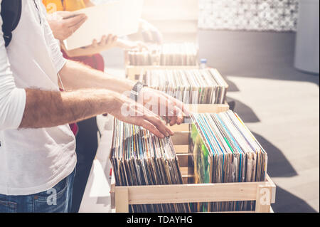 L'homme parcourt l'album vinyle en vente. Image main d'hommes beaux dans le cadre. Banque D'Images