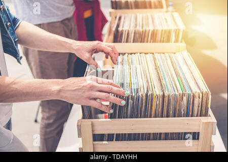 Femme choisissant vinyl records en vente. Les mains de femmes élégantes dans le cadre. Banque D'Images