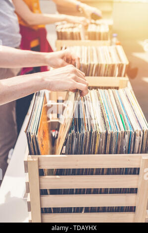Femme choisissant vinyl records en vente. Les mains de femmes élégantes dans le cadre. Shot verticale Banque D'Images