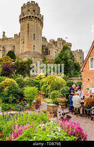 Les visiteurs de l'usine jardin avec sa vue de la tour César, le château de Warwick. Warwick, Royaume-Uni. L'été 2018. Banque D'Images