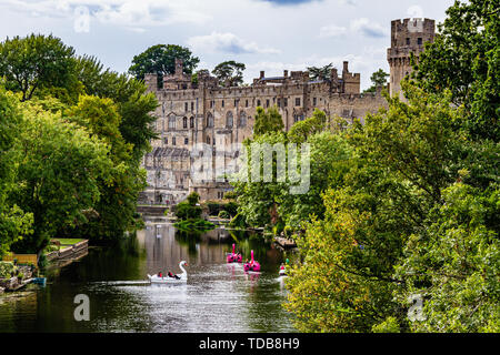 Le Château de Warwick avec des touristes dans la location de bateaux sur la rivière Avon. Warwick, Warwickshire, Royaume-Uni. L'été 2018. Banque D'Images