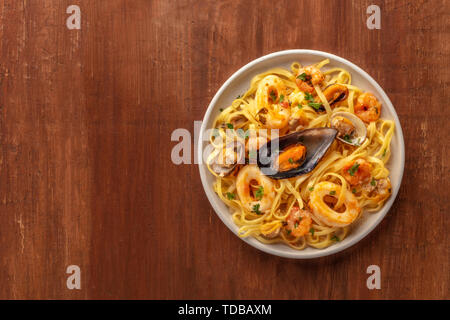 Pâtes aux fruits de mer. Tagliolini aux moules, crevettes, palourdes et calamars, tourné par le haut sur un fond de bois rustique foncé avec copyspace Banque D'Images