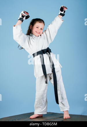 Karate fighter prêt à combattre. Karate sport concept. Compétences d'auto-défense. Le karaté donne un sentiment de confiance. Kid forte et confiante. Elle est dangereuse. Petit enfant fille en kimono blanc avec ceinture. Banque D'Images